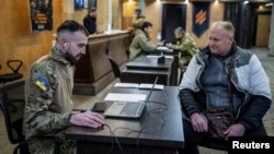 Un voluntar care urmează să se alăture Brigăzii 3 de Asalt Separate a Ucrainei discută cu ofițerii de recrutare (fotografie de arhivă)