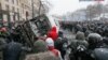 Шерушілер өртенген полиция көлігін төңкеріп жатыр. Киев, 21 қаңтар 2014 жыл.