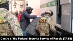 Співробітники ФСБ затримують кримчанина після обшуку, архівне фото