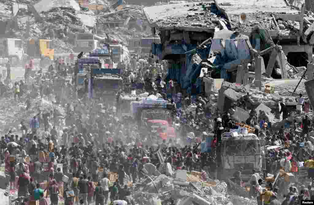 12 octombrie 2025 – Palestinienii din Khan Younis, oraș din sudul Fâșiei Gaza, așteaptă să primească ajutoare umanitare din camioanele care au intrat în Gaza, în contextul încetării focului între Israel și Hamas.