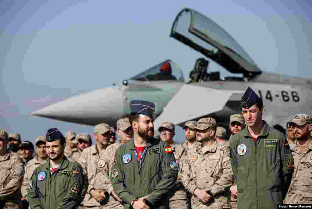 Іспанські пілоти та військовослужбовці стоять перед літаком Eurofighter Typhoon під час церемонії на авіабазі Граф Ігнатьєво в центральній Болгарії 17 лютого 2022 року. Німецькі та іспанські літаки 17 лютого прибули на військові бази в Румунії та Болгарії. Це відбувається в рамках розгортання повітряних сил на східних флангах НАТО на тлі створеної Росією напруженості навколо України